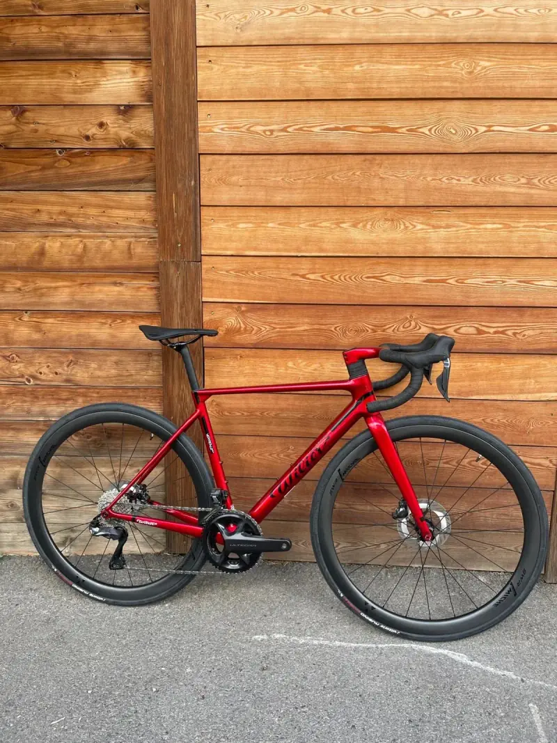 Vélo de route rouge léger conçu pour gravir les grands cols